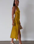 Satin maxi dress. Adjustable halter tie neckline. Side hook and eye and zipper closures. Front slit. Back tie closure. Partially lined. gold dress. gold midi dress. guest wedding dress. fall wedding.