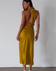 Satin maxi dress. Adjustable halter tie neckline. Side hook and eye and zipper closures. Front slit. Back tie closure. Partially lined. gold dress. gold midi dress. guest wedding dress. fall wedding.