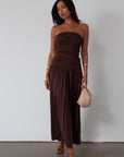 Knit maxi dress. Strapless elastic neckline. Inner rubber grip lining. Ruched slides. Partially lined. brown maxi dress. brown starpless maxi dress. summer dress. wedding guest dress