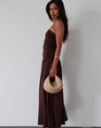 Knit maxi dress. Strapless elastic neckline. Inner rubber grip lining. Ruched slides. Partially lined. brown maxi dress. brown starpless maxi dress. summer dress. wedding guest dress