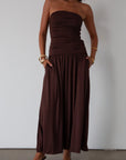 Knit maxi dress. Strapless elastic neckline. Inner rubber grip lining. Ruched slides. Partially lined. brown maxi dress. brown starpless maxi dress. summer dress. wedding guest dress