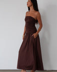 Knit maxi dress. Strapless elastic neckline. Inner rubber grip lining. Ruched slides. Partially lined. brown maxi dress. brown starpless maxi dress. summer dress. wedding guest dress