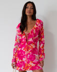 Printed chiffon dress. Long sleeves with tie closure. Front and back tie closures. Ruffle deep v-neckline. Side zipper closure. Fully lined. floral mini dress. pink floral mini dress