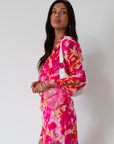 Printed chiffon dress. Long sleeves with tie closure. Front and back tie closures. Ruffle deep v-neckline. Side zipper closure. Fully lined. floral mini dress. pink floral mini dress