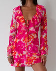 Printed chiffon dress. Long sleeves with tie closure. Front and back tie closures. Ruffle deep v-neckline. Side zipper closure. Fully lined. floral mini dress. pink floral mini dress