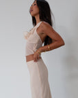 Chiffon crop top. Halter neckline with back button closures. Ruffle trimmed deep v-neckline. Side hook and eye and zipper closures. Partially lined. ruffle top. ruffle tank top. nude top. coquette top