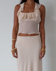 Chiffon crop top. Halter neckline with back button closures. Ruffle trimmed deep v-neckline. Side hook and eye and zipper closures. Partially lined. ruffle top. ruffle tank top. nude top. coquette top
