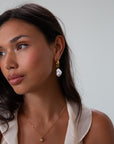 Small thick hoop earrings with pearl drop detail. Hinge closure.
