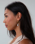 Small thick hoop earrings with pearl drop detail. Hinge closure.