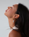 Small thick hoop earrings with pearl drop detail. Hinge closure.