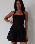 Woven dress. Halter neckline with button closures. Side pockets. Back hook and eye and zipper closures. Fully lined. black mini dress. black mini bubble dress. summer dress