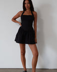 Woven dress. Halter neckline with button closures. Side pockets. Back hook and eye and zipper closures. Fully lined. black mini dress. black mini bubble dress. summer dress
