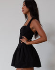 Woven dress. Halter neckline with button closures. Side pockets. Back hook and eye and zipper closures. Fully lined. black mini dress. black mini bubble dress. summer dress