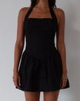 Woven dress. Halter neckline with button closures. Side pockets. Back hook and eye and zipper closures. Fully lined. black mini dress. black mini bubble dress. summer dress