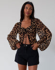 Animal printed chiffon top. Long sleeves with elastic openings. Underwire cups. Front lace up closures. Lace trim. Partially lined. leopard top. cheetah top. going out top. summer top