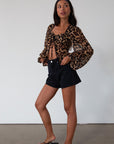 Animal printed chiffon top. Long sleeves with elastic openings. Underwire cups. Front lace up closures. Lace trim. Partially lined. leopard top. cheetah top. going out top. summer top