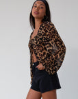 Animal printed chiffon top. Long sleeves with elastic openings. Underwire cups. Front lace up closures. Lace trim. Partially lined. leopard top. cheetah top. going out top. summer top
