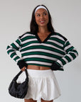 Striped ribbed knit crop top. Collar neckline. Long sleeves. Raw hem. Unlined. green and white stripe sweater long sleeve top