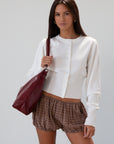 Vegan leather bag. Detachable top strap. Detachable shoulder strap. Top zipper closure. Fully lined. Inner pockets.