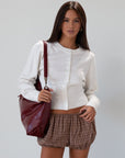 Vegan leather bag. Detachable top strap. Detachable shoulder strap. Top zipper closure. Fully lined. Inner pockets.