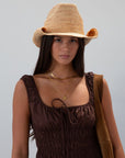 Straw cowboy hat. Pinched crown. Upturned brim.