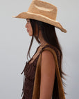 Straw cowboy hat. Pinched crown. Upturned brim.