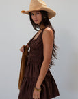 Smocked woven dress. Elastic straps. Front tie closure. Elastic waist. Side pockets. Fully lined. brown mini dress. fall transition dress