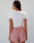Checkered woven shorts. Elastic waist. Faux button fly. Ruffle trim hem. Unlined. red checkered shorts