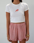 Checkered woven shorts. Elastic waist. Faux button fly. Ruffle trim hem. Unlined. red checkered shorts