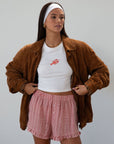 Checkered woven shorts. Elastic waist. Faux button fly. Ruffle trim hem. Unlined. red checkered shorts