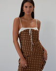 Polka dot printed satin dress. Adjustable straps. Front tie closure. Back hook and eye and zipper closures. Fully lined. brown mini dress. brown polka dot dress. fall outfit