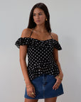 Polka dot printed chiffon crop top. Ruffle trim. Elastic off the shoulder short sleeves. Front tie closure. Boning in bodice. Back hook and eye and zipper closures. Fully lined. black polka dot top. going out top fall top. fall outfit.