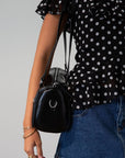 Vegan leather bag. Fixed top straps. Adjustable/detachable strap. Top zipper closure. Outer zipper pockets. Fully lined with inner zipper pocket.