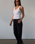 Mid rise bowed straight leg jeans. Button and zipper fly. Five pocket construction. Straight leg bows at the knees for an arched, barrel leg silhouette. Ankle length crop with a clean hem. No stretch. BLACK DENIM JEANS