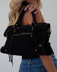 black Suede bag. Adjustable/detachable strap. Fixed top handles. Top zipper closure. Front zipper pocket. Fully lined. Inner pockets and zipper pocket.