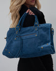 blue Suede bag. Adjustable/detachable strap. Fixed top handles. Top zipper closure. Front zipper pocket. Fully lined. Inner pockets and zipper pocket.
