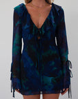 Printed chiffon dress. Long sleeves with tie closures. Ruffle trim. Front and back tie closures. Side zipper closure. Fully lined. mini dress. blue and green mini dress. fall outfit