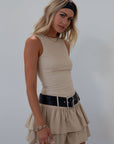 Knit sleeveless dress. Tiered skirt. Adjustable/detachable vegan leather belt. Back hook and eye and zipper closures. Fully lined.