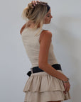 Knit sleeveless dress. Tiered skirt. Adjustable/detachable vegan leather belt. Back hook and eye and zipper closures. Fully lined.