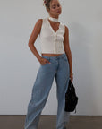 Ribbed knit sleeveless top. V-neckline. Front button down closure. Unlined. Neck tie. white top. white knit vest. fall outfit. fall top. fall transition top.
