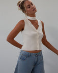 Ribbed knit sleeveless top. V-neckline. Front button down closure. Unlined. Neck tie. white top. white knit vest. fall outfit. fall top. fall transition top.