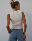 Ribbed knit sleeveless top. V-neckline. Front button down closure. Unlined. Neck tie. white top. white knit vest. fall outfit. fall top. fall transition top.