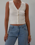 Ribbed knit sleeveless top. V-neckline. Front button down closure. Unlined. Neck tie. white top. white knit vest. fall outfit. fall top. fall transition top.