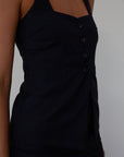 Plaid woven sleeveless top. Front button down closure. Faux front pockets. Adjustable back tie closure. Fully lined. navy blue blouse. work outfit. business casual outfit.