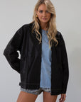 Vegan leather oversized jacket. Collar neckline. Snap button sleeve closures. Exposed front zipper closure. Front pockets with exposed zipper closures. Adjustable sides. Fully lined. 