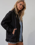 Vegan leather oversized jacket. Collar neckline. Snap button sleeve closures. Exposed front zipper closure. Front pockets with exposed zipper closures. Adjustable sides. Fully lined. 