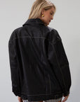 Vegan leather oversized jacket. Collar neckline. Snap button sleeve closures. Exposed front zipper closure. Front pockets with exposed zipper closures. Adjustable sides. Fully lined. 
