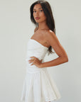 Woven mini dress. Strapless neckline. Inner rubber grip lining. Ruched bodice. Back hook and eye and zipper closure. Fully lined. white mini dress. white strapless mini dress. bridal shower dress. bridal dress. engagement dress. bride outfit. summer dress. fancy dinner dress