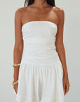 Woven mini dress. Strapless neckline. Inner rubber grip lining. Ruched bodice. Back hook and eye and zipper closure. Fully lined. white mini dress. white strapless mini dress. bridal shower dress. bridal dress. engagement dress. bride outfit. summer dress. fancy dinner dress