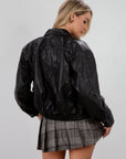 Vegan leather bomber jacket. Collar neckline. Long sleeves with snap button closures. Front snap button and zipper closures. Front pockets. Elastic hem. Fully lined. dark brown faux leather bomber jacket. fall jacket. bomber jacket